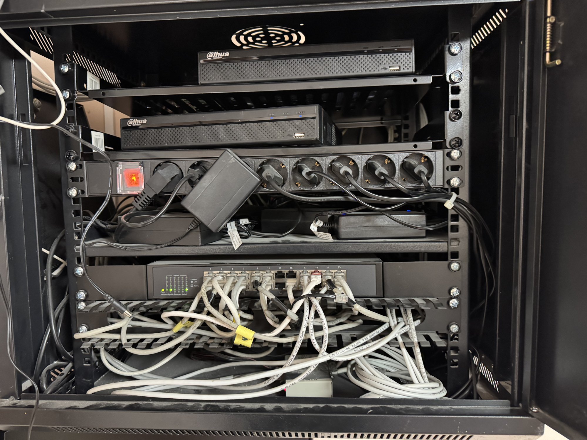 Szafa rack z poplątanym, nieuporządkowanym okablowaniem